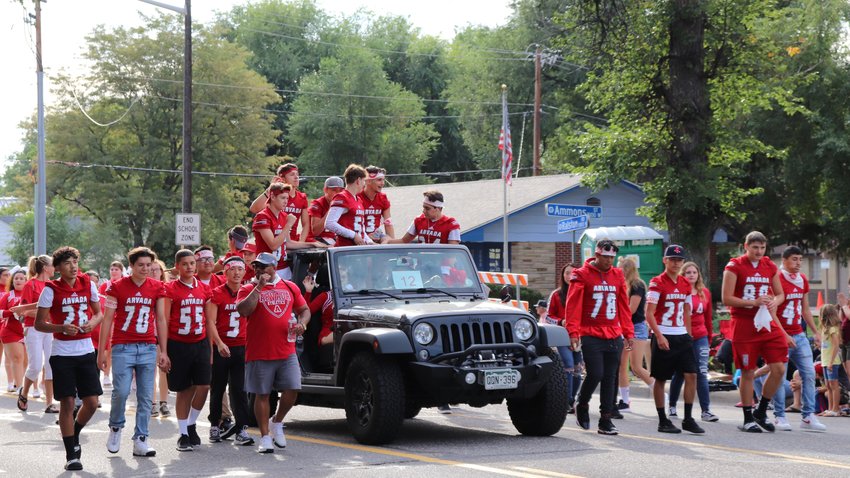 Football players show their support for Arvada High during the parade.